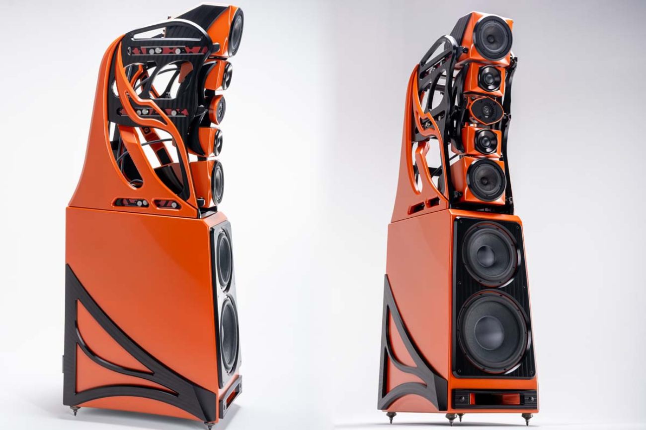 Vue d'ensemble de la paire d'enceintes flagship Wilson Audio Autobiography en finition Red Rock Sunset orange, montrant à gauche la vue 3/4 arrière avec le gantry skeletonized révélant l'architecture interne, et à droite la vue 3/4 avant détaillant la configuration M(MTM)M : driver médium 7 pouces PentaMag haut, ensemble MTM central avec tweeter CSLS encadré des deux drivers médium 2 pouces MID, driver PentaMag bas, et les deux woofers 12 et 15 pouces dans le coffret inférieur