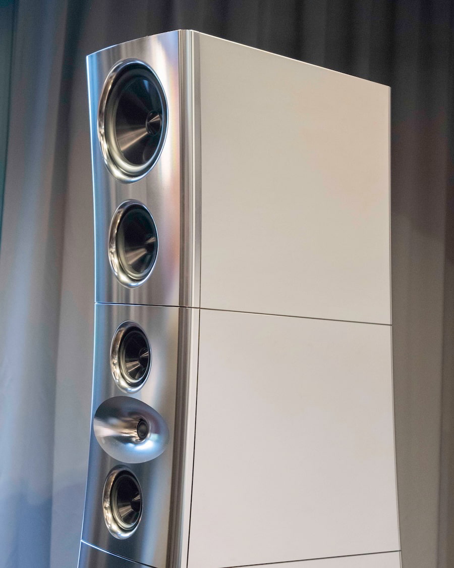 Vue rapprochée de la partie haute d'une enceinte YG Acoustics Titan en finition aluminium poli, montrant en plan serré le tweeter Lattice hybride 26 mm avec son airframe propriétaire en forme de soucoupe métallique, les drivers médiums 15 cm et médium-grave 18,5 cm encadrant, et la segmentation horizontale visible du cabinet en couches d'alliage aluminium aérospatial