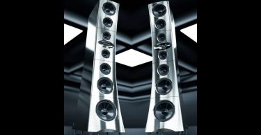 Paire d'enceintes colonnes YG Acoustics Titan en finition aluminium poli vue en perspective, avec configuration en array symétrique de 7 drivers à cônes aluminium et woofer sub-bass de 32 cm en partie basse, présentées sur fond noir avec reflets géométriques