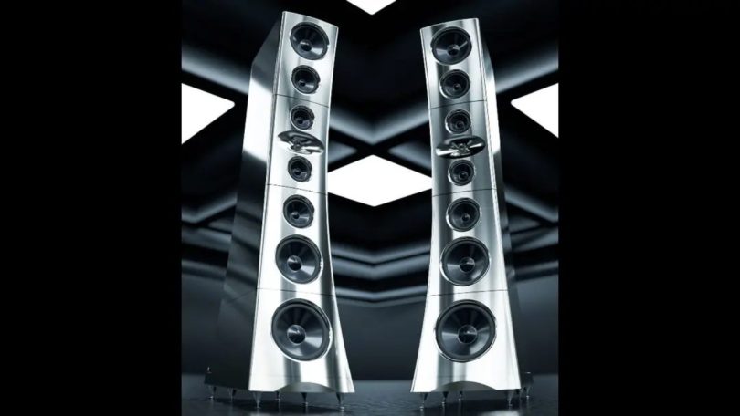 Paire d'enceintes colonnes YG Acoustics Titan en finition aluminium poli vue en perspective, avec configuration en array symétrique de 7 drivers à cônes aluminium et woofer sub-bass de 32 cm en partie basse, présentées sur fond noir avec reflets géométriques
