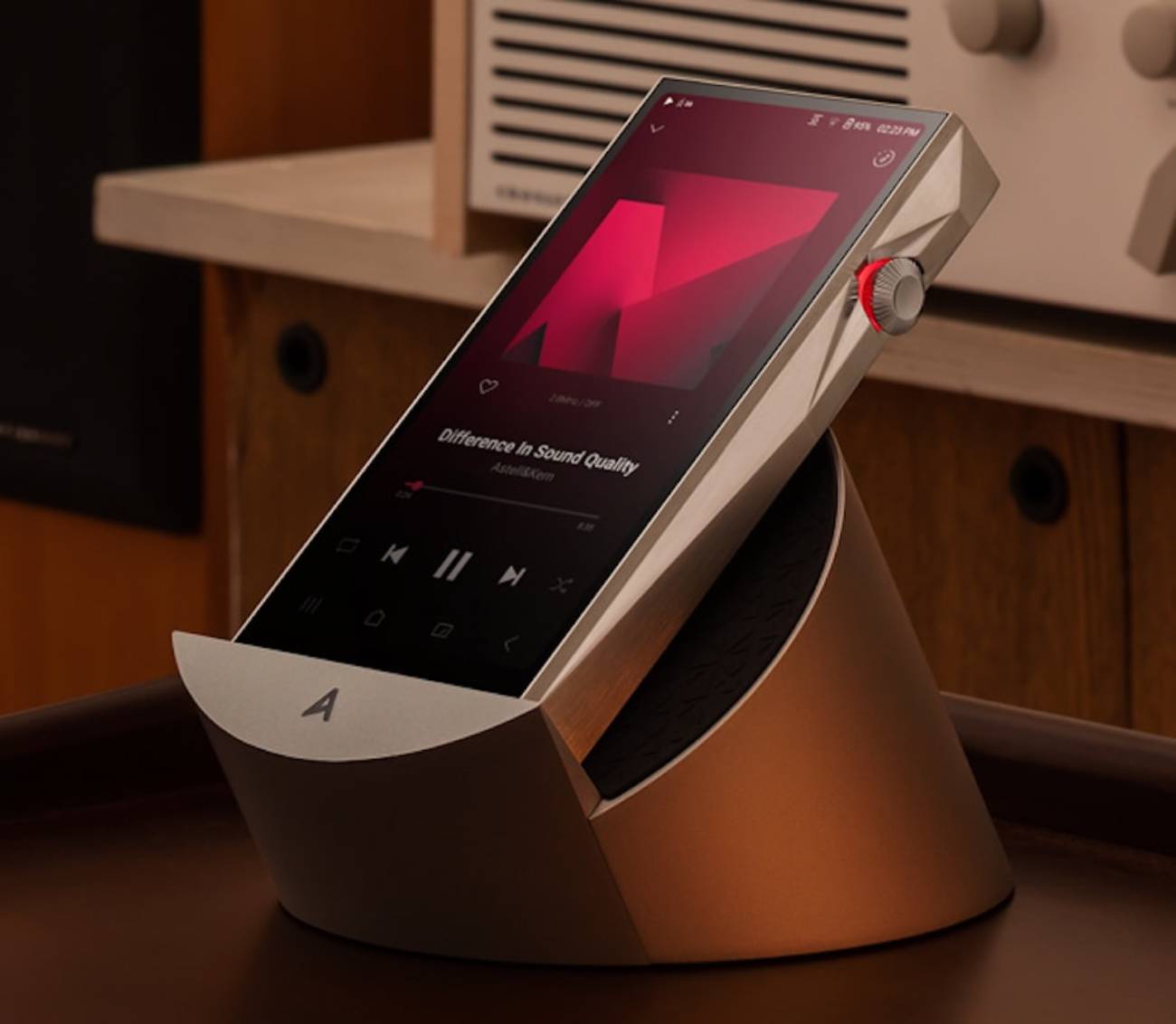Baladeur Astell&Kern SP4000T posé sur la station d'accueil AK Cradle en aluminium avec logo A, écran allumé sur l'interface Crimson, dans un salon hi-fi avec électronique vintage en arrière-plan