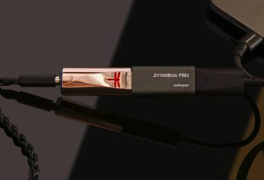 DAC USB nomade AudioQuest DragonFly Copper au boîtier plaqué cuivre avec logo libellule rouge, relié à un filtre JitterBug FMJ puis à un adaptateur DragonTail USB-C branché sur un ordinateur portable, sortie casque 3,5 mm à gauche