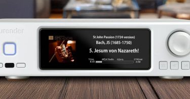 Aurender DA100, streaming DAC dual-mono AK4499 en finition blanche posé sur un plan en bois, écran IPS affichant une lecture TIDAL haute résolution, bouton de veille rétroéclairé bleu à gauche et molette de volume à droite