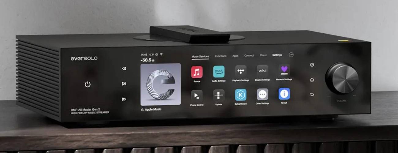 Eversolo DMP-A8 Master Gen 2 en finition noire posé sur un meuble bois, grand écran tactile 8,6 pouces affichant les services de streaming, molette de volume à droite et télécommande sur le dessus, streamer DAC préamplificateur tout-en-un