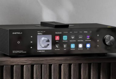 Eversolo DMP-A8 Master Gen 2 en finition noire posé sur un meuble bois, grand écran tactile 8,6 pouces affichant les services de streaming, molette de volume à droite et télécommande sur le dessus, streamer DAC préamplificateur tout-en-un