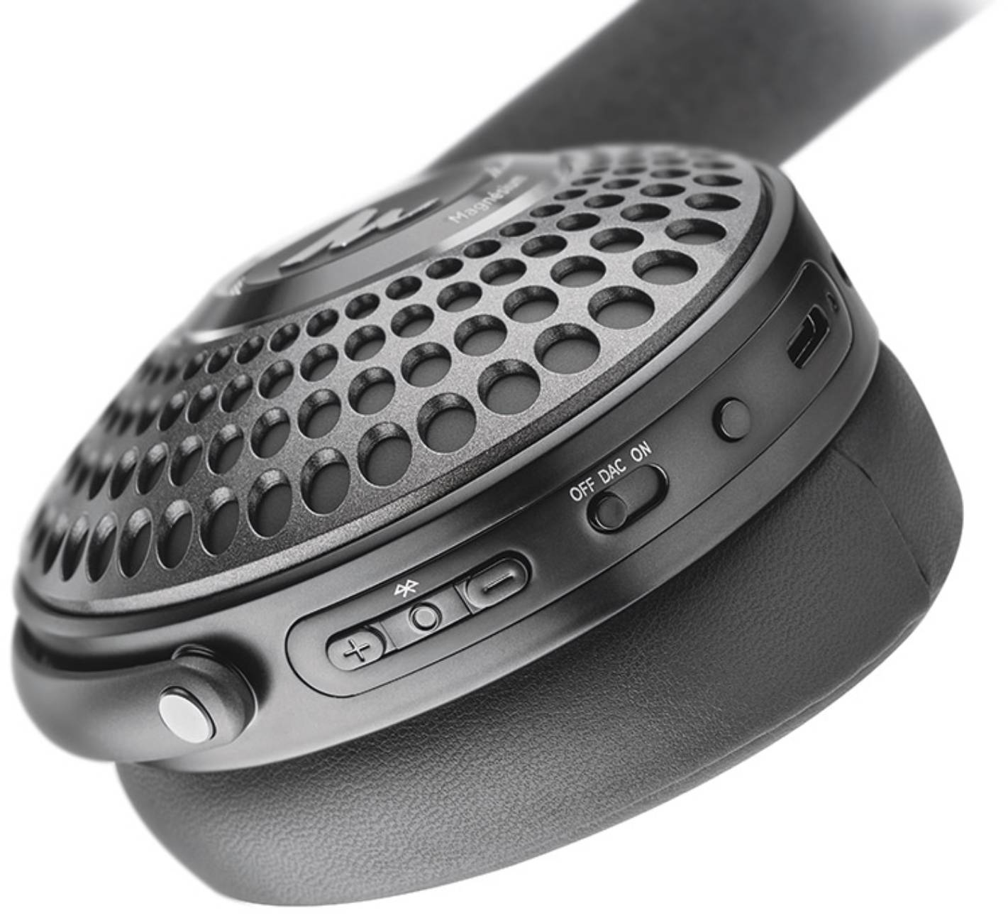 Macro de l'oreillette du casque Focal Bathys MG Graphen Grey montrant la grille perforée, l'inscription Magnesium et le logo Focal, le curseur trois positions OFF DAC ON, les boutons volume avec symbole Bluetooth et le port USB-C sur la tranche