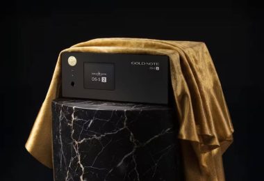 Streamer DAC Gold Note DS-5.2 en finition noire posé sur un socle en marbre noir veiné de blanc avec drapé de velours doré, façade aluminium anodisé noir avec écran tactile couleur, molette ronde dorée et logo Gold Note