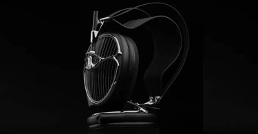 Casque audiophile ouvert Meze Audio ARTA en finition noire posé sur un socle en cuir, grille sculpturale aux lames acoustiques inclinées, arceau suspendu et driver planar magnétique MZ5 HΩ 225 ohms visible