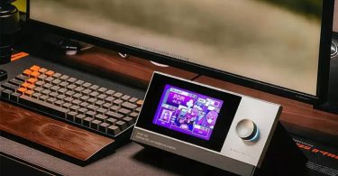Le DAC ampli casque de bureau Muse HiFi Muse 300 en finition aluminium posé sur un bureau, écran 5 pouces affichant le thème ACG anime, molette de volume à droite, à côté d'un clavier mécanique
