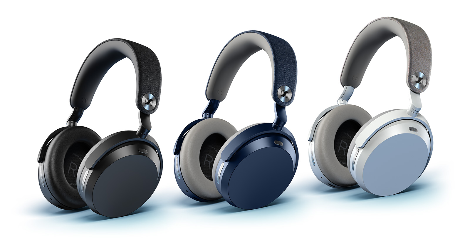 Les trois coloris du casque Sennheiser Momentum 5 Wireless alignés sur fond blanc : noir avec arceau textile sombre, denim bleu avec arceau gris, et blanc avec oreillette bleu clair, oreillettes ovales aux accents métalliques et logo Sennheiser sur l'arceau