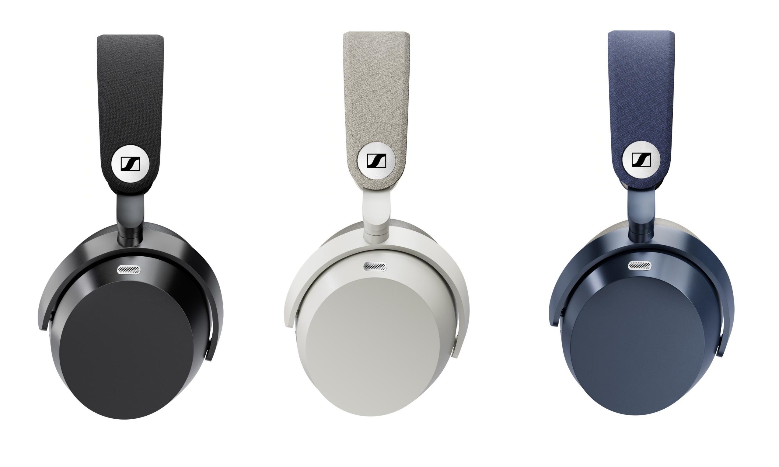 Trois casques Sennheiser Momentum 5 Wireless vus de profil en position lay-flat sur fond blanc, en noir, blanc et denim, montrant l'arceau habillé de textile avec le médaillon logo Sennheiser et la grille de microphone sur le flanc de l'oreillette