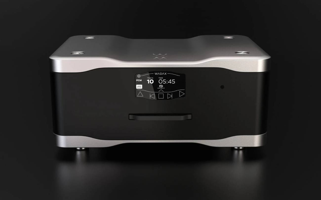 Lecteur CD/SACD Wadax Studio Transport vu de face, châssis noir et capot aluminium sculpté, écran tactile affichant PCM, piste 10, durée 05:45 et le mode Akasa Optical, commandes de transport et fente de chargement frontale du disque, sur fond sombre