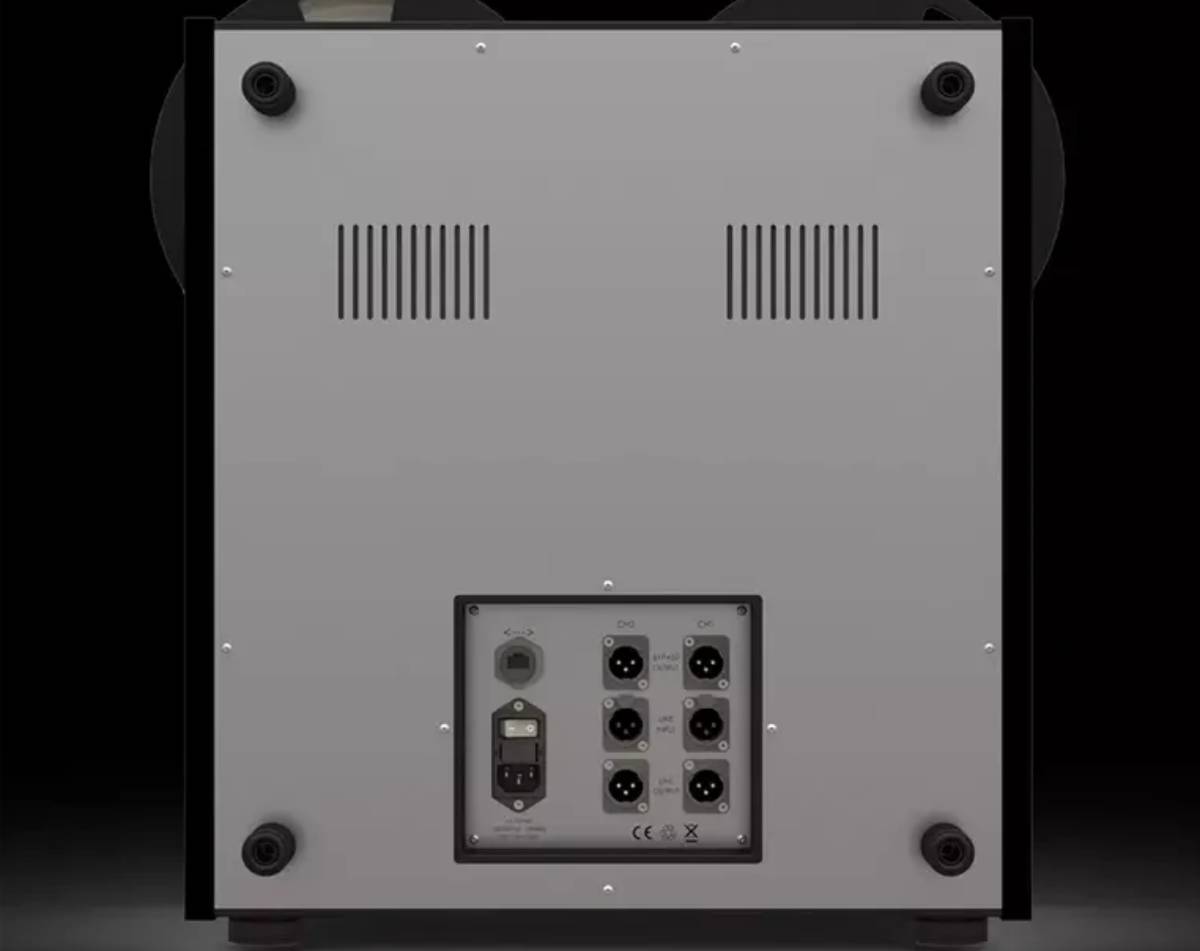 Panneau arrière du magnétophone Analog Audio Design TR-1100 sur fond noir : capot gris avec deux grilles de ventilation, quatre plots de protection aux angles, et platine de connectique encastrée regroupant six connecteurs XLR répartis en colonnes CH1 et CH2 pour BYPASS OUTPUT, LINE INPUT et LINE OUTPUT, une embase réseau et une embase secteur IEC avec interrupteur et porte-fusible