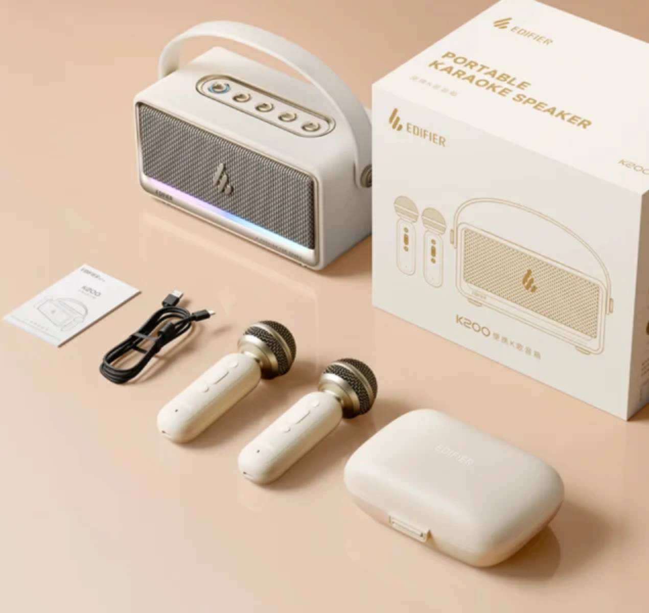 Contenu complet du coffret Edifier K200 en finition ivoire : enceinte karaoké portable avec bandeau LED allumé et poignée blanche, emballage carton Portable Karaoke Speaker, notice, câble de charge USB, deux micros sans fil ivoire à grille dorée et coffret de rangement rigide