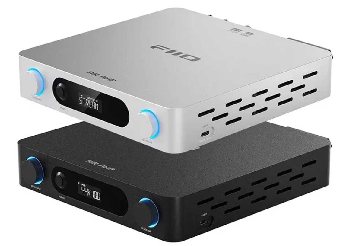 Les deux finitions de l'amplificateur de streaming FiiO Air Amp empilées et vues de trois quarts : châssis argent en haut avec logo FiiO et marquage AIR AMP sur le capot, châssis noir en dessous, tous deux équipés d'une molette MENU/INPUT à gauche, d'un bouton POWER, d'un écran LCD affichant STREAM sur l'argent et 44K sur le noir, d'une molette VOLUME rétroéclairée bleu et d'un port USB-C USB IN en façade, avec grille de ventilation à lamelles sur le flanc droit