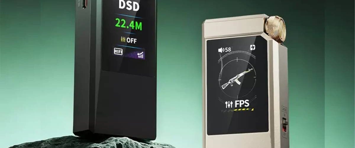 Les deux finitions du DAC portable FiiO QX11 posées sur un rocher, la version vert foncé affichant DSD 22.4M sur son écran LCD couleur et la version or affichant le preset gaming FPS, molette de volume crantée et double port USB-C visibles