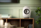 Enceinte active sans fil KEF LS LUXE Mineral White posée sur un meuble dans un salon