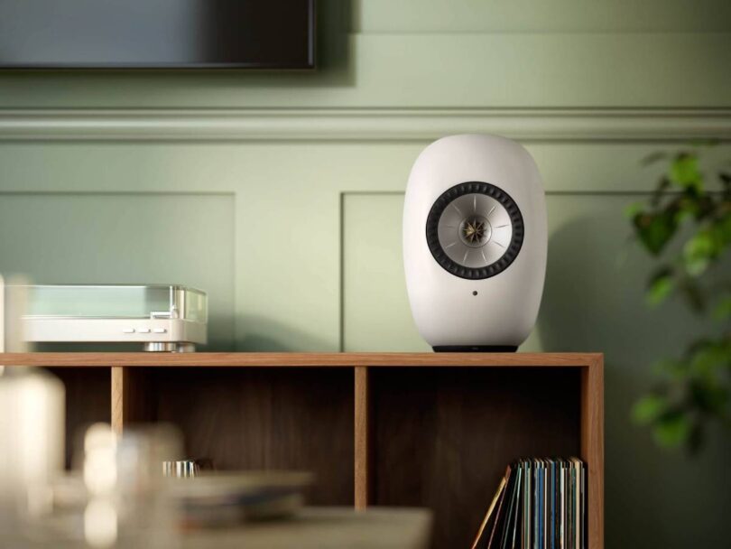Enceinte active sans fil KEF LS LUXE Mineral White posée sur un meuble dans un salon