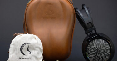 Casque planar magnétique ouvert Sendy Audio Apollo PRO à grille métallique sunburst et arceau noir, présenté avec son étui de transport rigide en cuir marron et sa pochette de rangement en chanvre