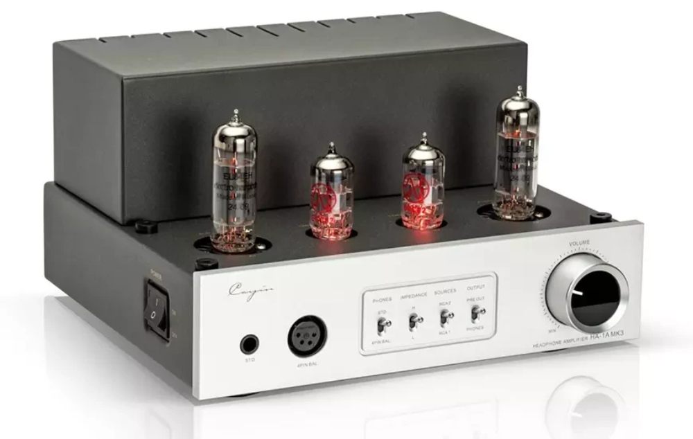Ampli casque à lampes Cayin HA-1A MK3 en finition argent vu de trois-quarts, avec deux tubes EL84EH et deux 12AU7 allumés, sortie jack 6,35 mm, prise XLR 4 broches, sélecteurs et volume