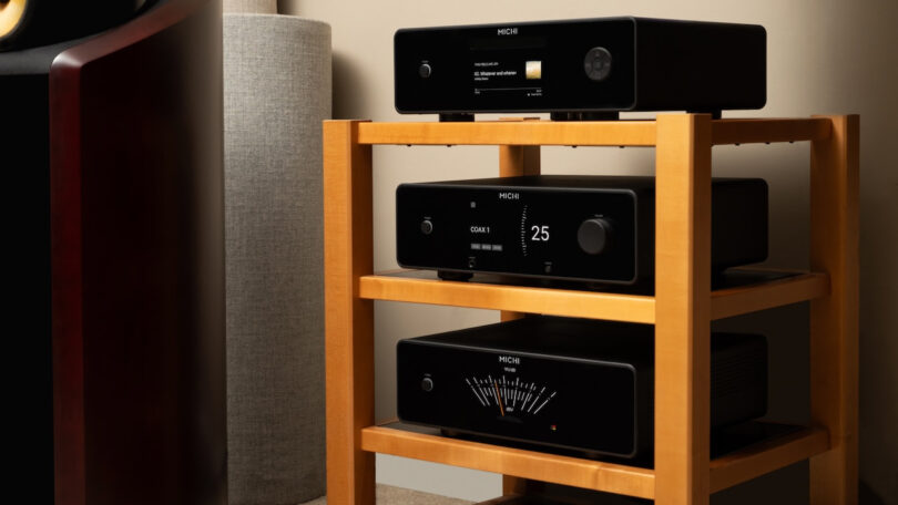 Trois appareils Michi Prestige empilés, lecteur CD Q430, préampli P430 et ampli S430, avec façades noires, écrans TFT couleur et vumètre, près d'une enceinte colonne