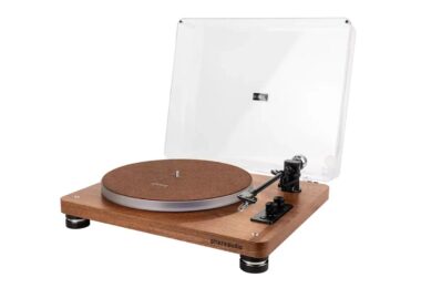 Platine vinyle Phaze Audio Celine en finition noyer avec capot transparent ouvert, couvre-plateau en feutre brun logoté phaze, bras de lecture noir de 9 pouces avec contrepoids chromé, commandes rotatives et pieds cylindriques