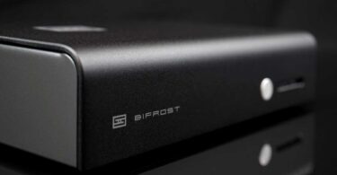 DAC Schiit Bifrost 3 en finition argent vu de trois quarts, façade en aluminium brossé avec logo Schiit, inscription Bifrost, bouton de sélection et nouvelle barre lumineuse d'indication des entrées