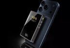 DAC R2R portable YBA VIBE P1 avec façade en verre miroir, logo YBA P1 dans la fenêtre smile et boutons latéraux, fixé au dos d'un smartphone sur fond noir