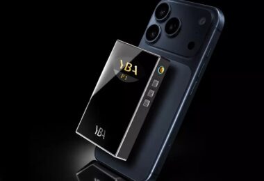 DAC R2R portable YBA VIBE P1 avec façade en verre miroir, logo YBA P1 dans la fenêtre smile et boutons latéraux, fixé au dos d'un smartphone sur fond noir