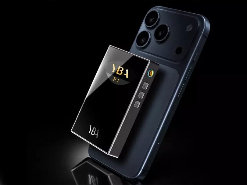 DAC R2R portable YBA VIBE P1 avec façade en verre miroir, logo YBA P1 dans la fenêtre smile et boutons latéraux, fixé au dos d'un smartphone sur fond noir
