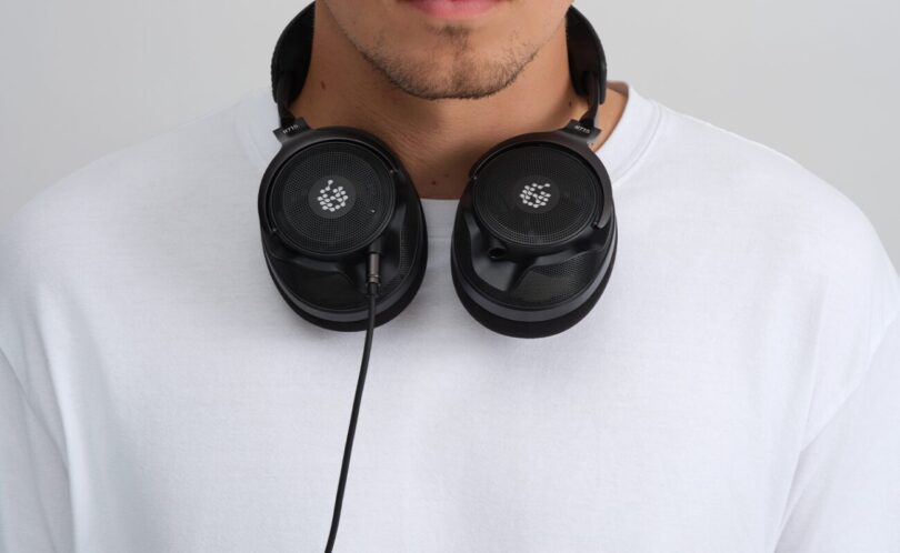 Casque ouvert ADAM Audio H715 Reference noir porté autour du cou, coques ajourées et câble jack visibles