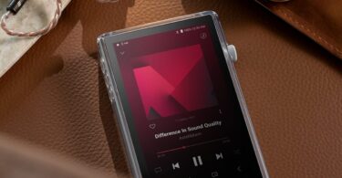 Baladeur audiophile Astell&Kern PD5 posé sur du cuir dans son étui TPU transparent, écran tactile 4,1 pouces en lecture DSD, molette de volume crantée et écouteurs intra-auriculaires