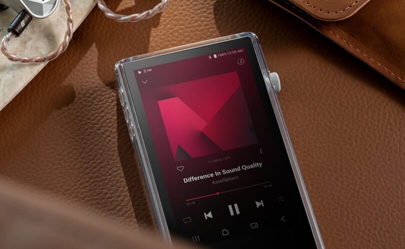 Baladeur audiophile Astell&Kern PD5 posé sur du cuir dans son étui TPU transparent, écran tactile 4,1 pouces en lecture DSD, molette de volume crantée et écouteurs intra-auriculaires