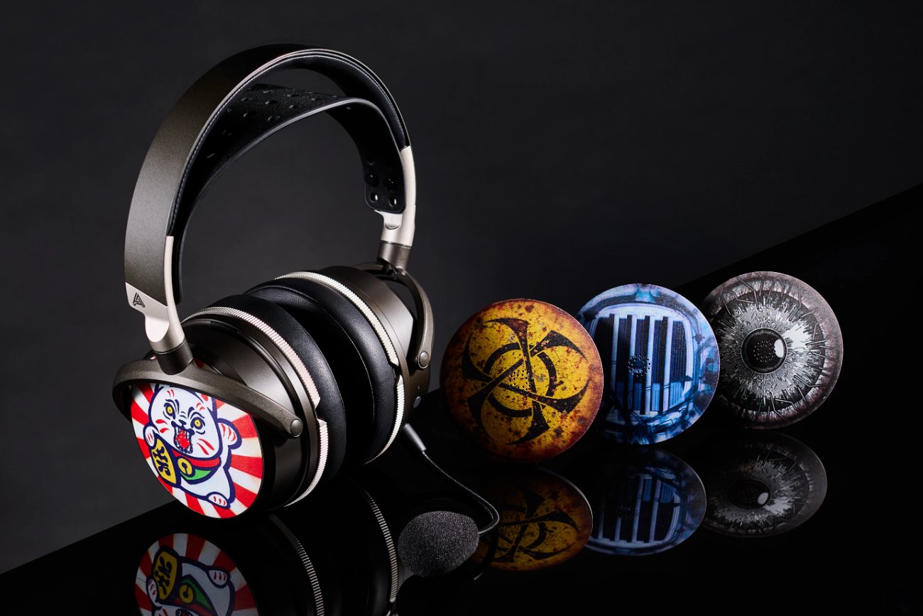 Casque Audeze Maxwell 2 ANC avec plaque latérale magnétique ReSkin illustrée, à côté de trois autres plaques ReSkin décorées posées sur une surface noire réfléchissante