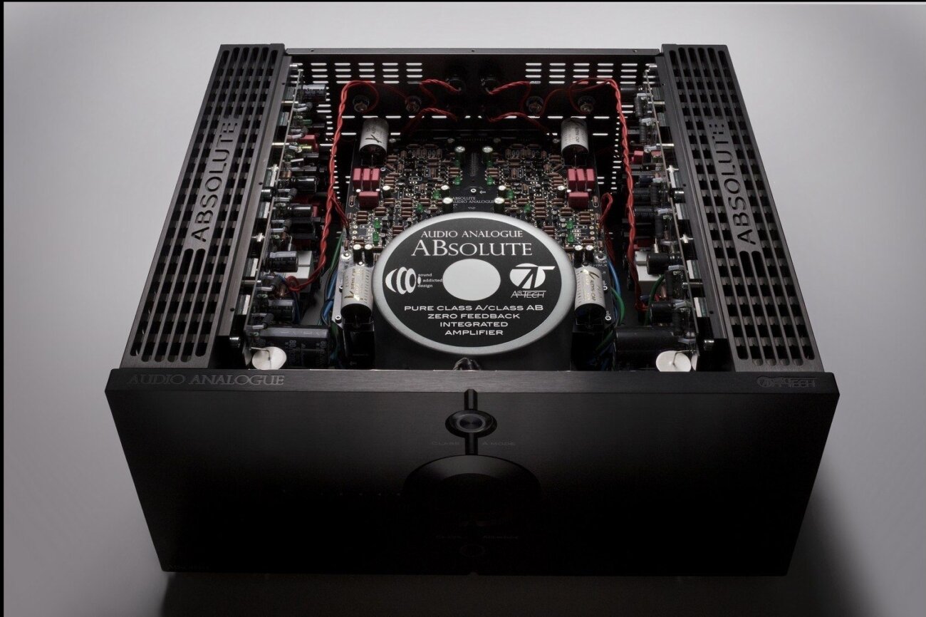 Vue intérieure de l'Audio Analogue ABsolute capot retiré : transformateur torique central, circuits de chaque canal de part et d'autre et dissipateurs à ailettes sur les flancs