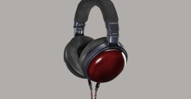 Casque fermé Audio-Technica ATH-AWX7000 vu de trois quarts, coques en cyprès Kiso laqué rouge, arceau et coussinets noirs, câble tressé cuivre