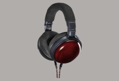 Casque fermé Audio-Technica ATH-AWX7000 vu de trois quarts, coques en cyprès Kiso laqué rouge, arceau et coussinets noirs, câble tressé cuivre