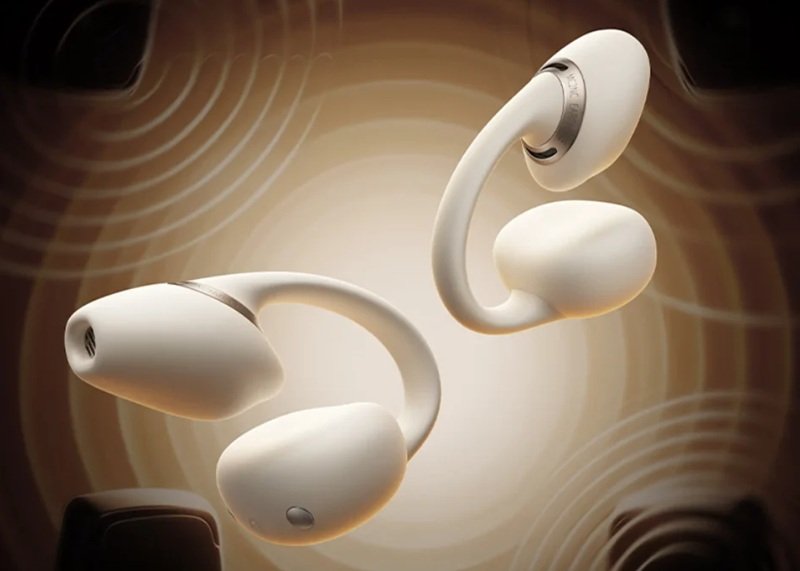 Paire d'écouteurs open-ear à clip Baseus MC2 NC coloris beige, arceau en C et bague métallique gravée, flottant devant des ondes sonores concentriques sur fond ambré