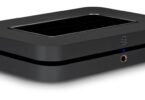 Streamer réseau Bluesound NODE noir vu de trois quarts sur fond blanc, avec surface tactile sur le dessus, logo Bluesound et prise casque en façade