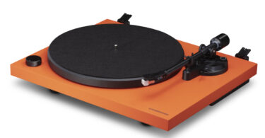 Platine vinyle Cambridge Audio Spira orange vue de trois quarts : plateau acier recouvert de feutrine, bras droit aluminium, cellule Audio-Technica AT3600L et bouton de vitesse 33/45 tours