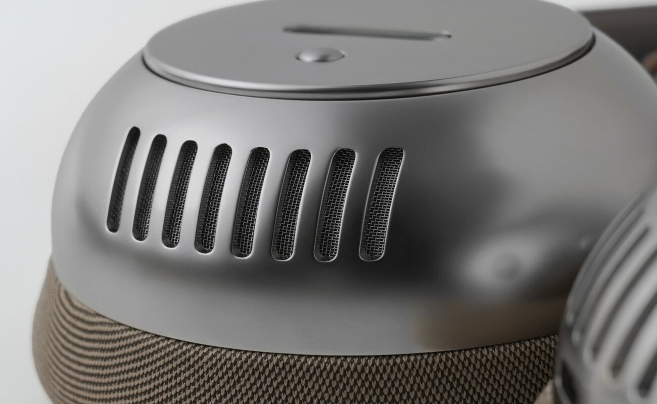 Oreillette du casque Bluetooth écoute TH2 en finition nickel avec coque métallique ajourée de fentes d'aération et coussinet en tissu beige