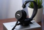 Casque ouvert Grado Signature S150 noir posé sur un appareil hi-fi argenté, grille de la coque avec logo Grado, arceau en cuir et câble détachable
