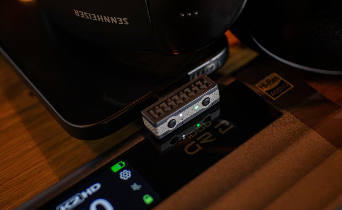 Émetteur Bluetooth iFi UP Play Max branché en USB-C à côté d'un casque, compatible aptX Lossless et LDAC