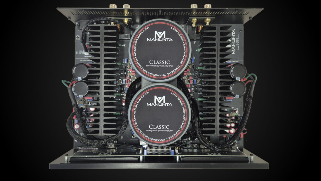 Vue interne de l'ampli de puissance Manunta Classic : deux transformateurs toriques superposés au centre et deux grands dissipateurs à ailettes de chaque côté