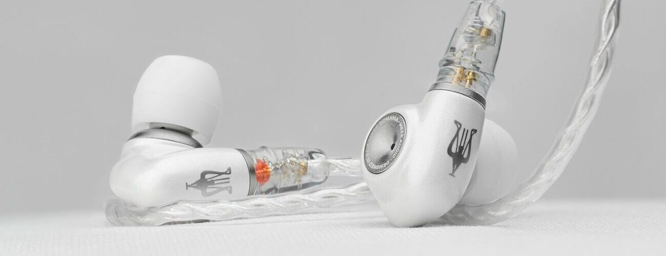 Intra-auriculaire Meze Audio ALBA S posé sur une surface claire, coque en alliage de zinc et aluminium anodisé blanc nacré, embout argenté et câble tressé argenté à connecteurs 2 broches