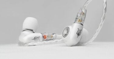 Intra-auriculaire Meze Audio ALBA S posé sur une surface claire, coque en alliage de zinc et aluminium anodisé blanc nacré, embout argenté et câble tressé argenté à connecteurs 2 broches