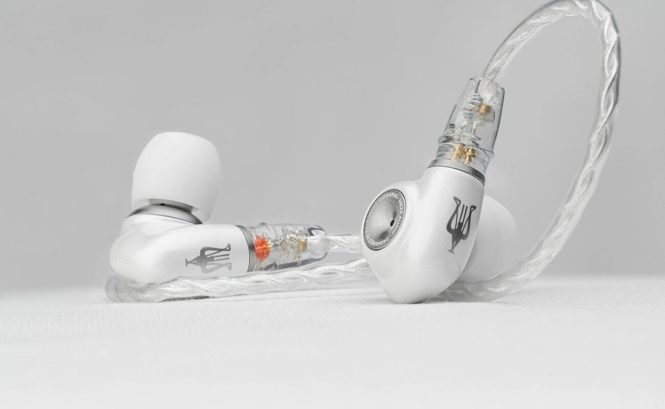 Intra-auriculaire Meze Audio ALBA S posé sur une surface claire, coque en alliage de zinc et aluminium anodisé blanc nacré, embout argenté et câble tressé argenté à connecteurs 2 broches