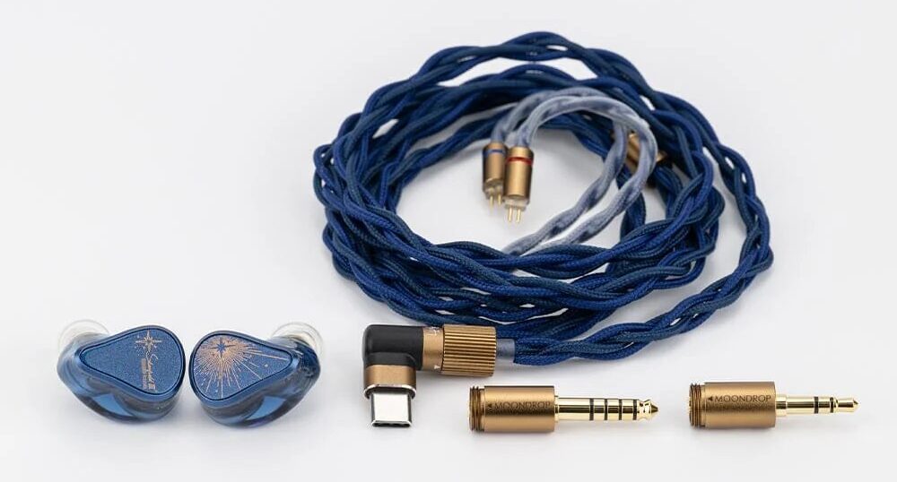 Moondrop Starfield 3 posé à côté de son câble tressé bleu et gris et de ses trois fiches dorées : USB-C coudée, jack 4,4 mm et jack 3,5 mm, sur fond blanc