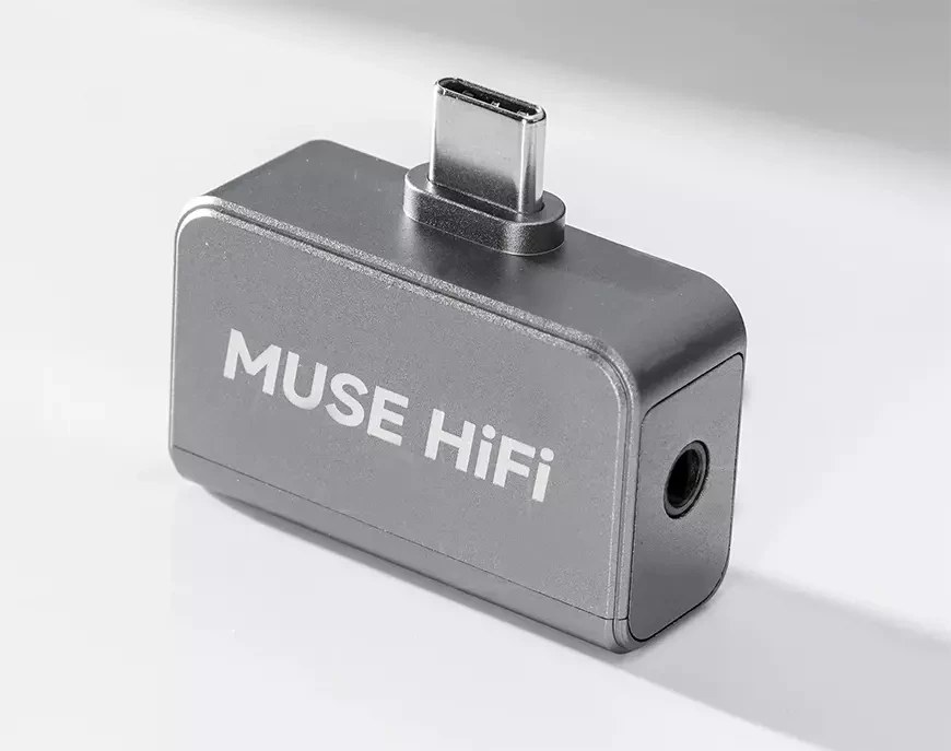 Dongle DAC Muse HiFi U3 en aluminium gris, vu de trois quarts, avec sa fiche USB-C mâle intégrée sur le dessus et sa sortie casque jack 3,5 mm sur le côté