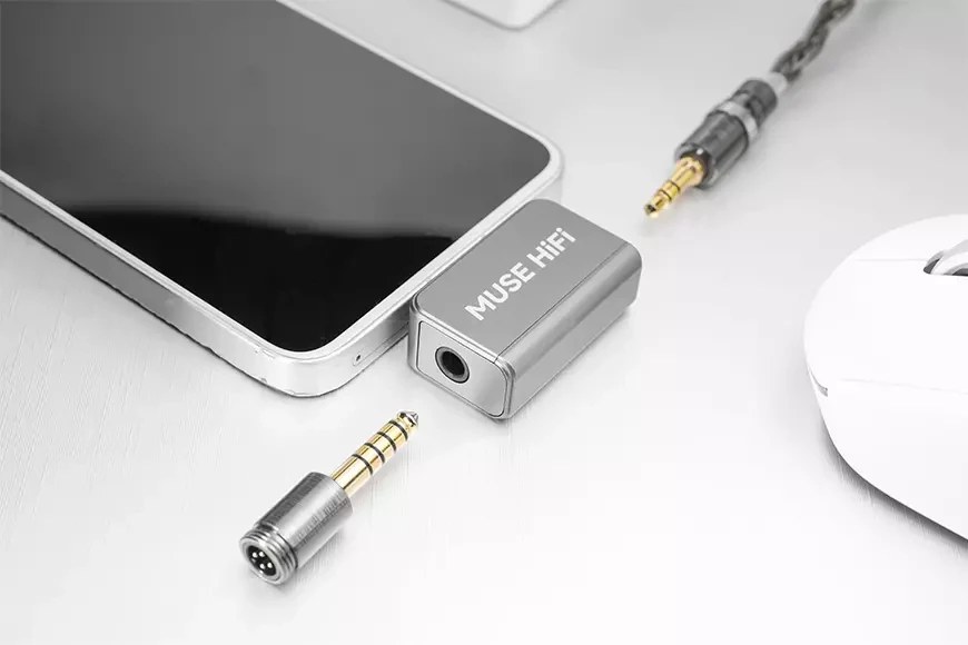 Dongle DAC Muse HiFi U3 gris branché sur le port USB-C d'un smartphone, avec un câble d'écouteurs terminé en jack 3,5 mm et un embout interchangeable 4,4 mm posé à côté